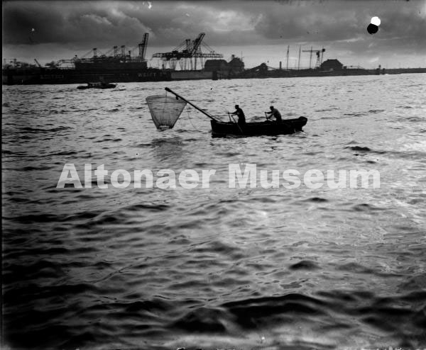 Kleines Fischerboot, mit dem Wurfnetz fischend, auf der Elbe