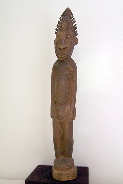 Frauenfigur aus Holz mit einem Kopf in der Vulva